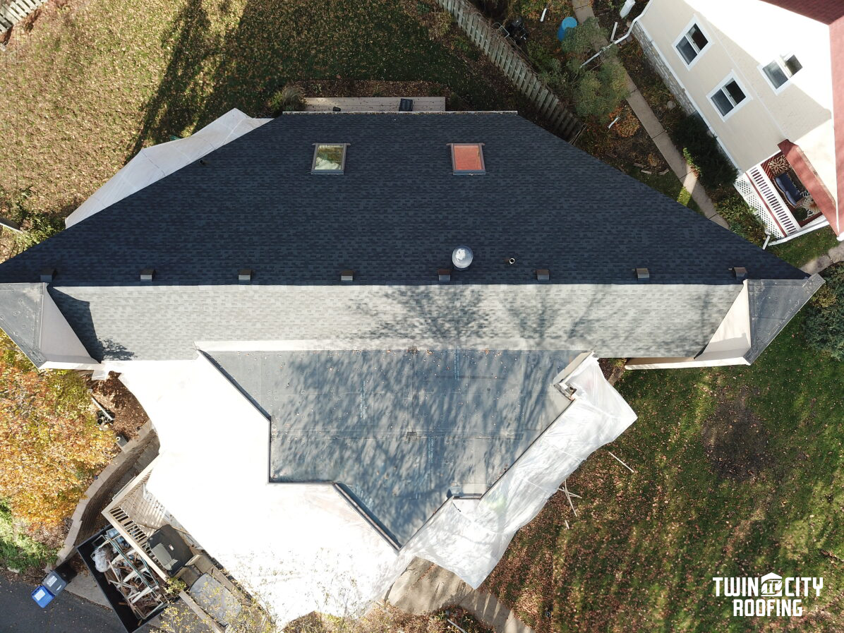 An aerial view of a house with a black roof.