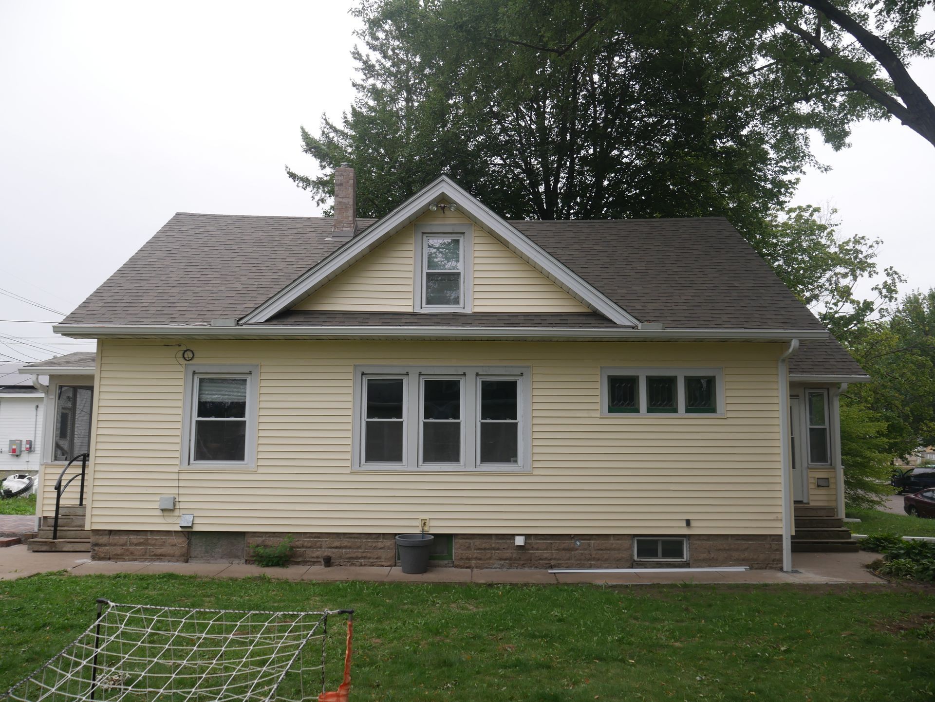 A small yellow house with a gray roof