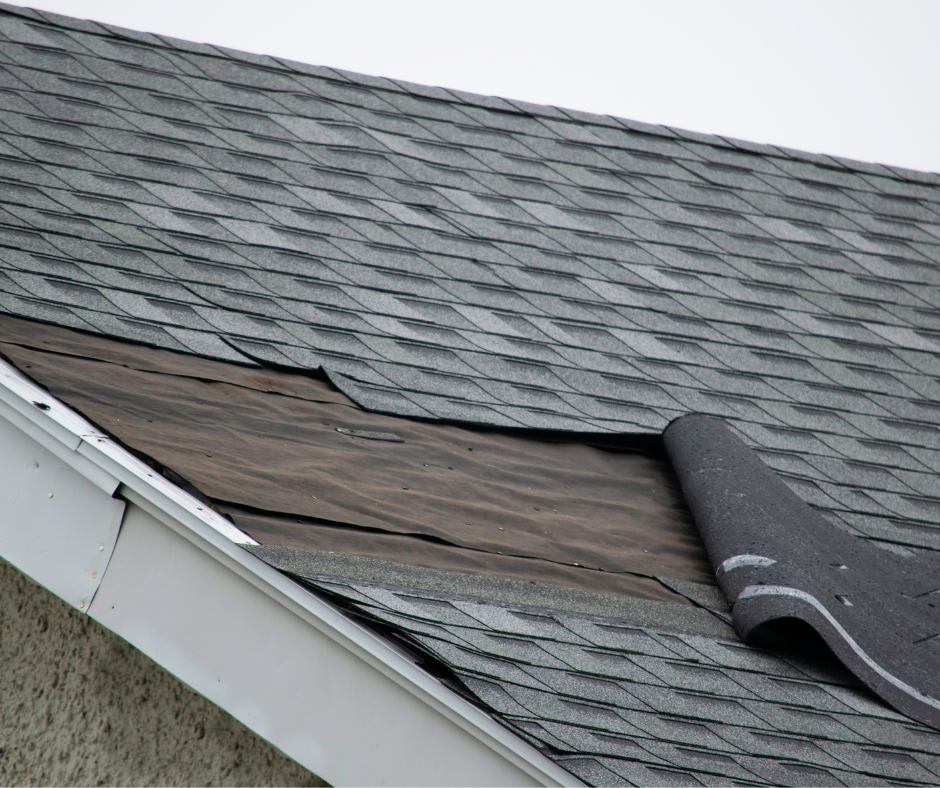 Grey Malarkey damaged shingles on a roof that are peeling back