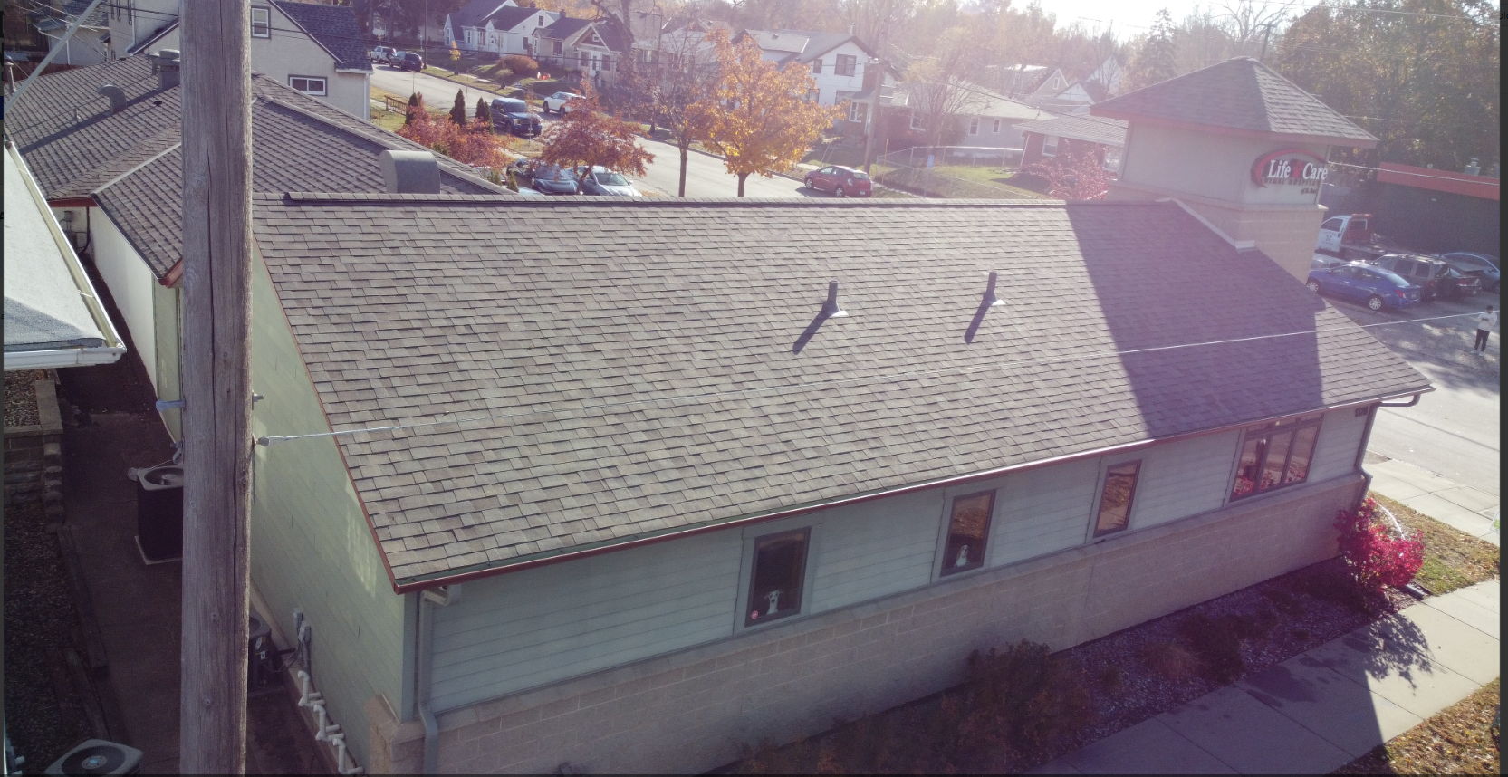 An aerial view of a house with a roof that is missing shingles.