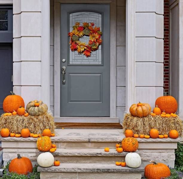 A Minnesota home with fall decorations, pumpkins, hay, and a wreath on the door