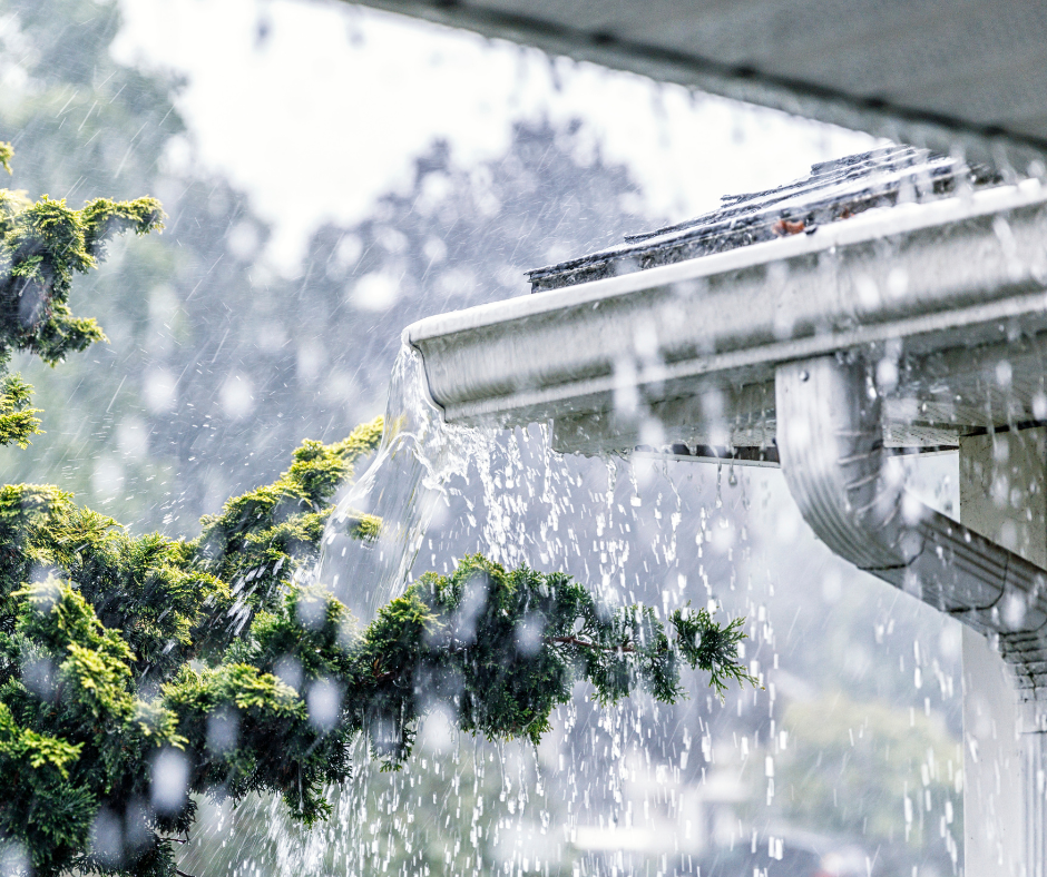 Clogged gutters on a St Paul home that are overflowing with water during a rainstorm