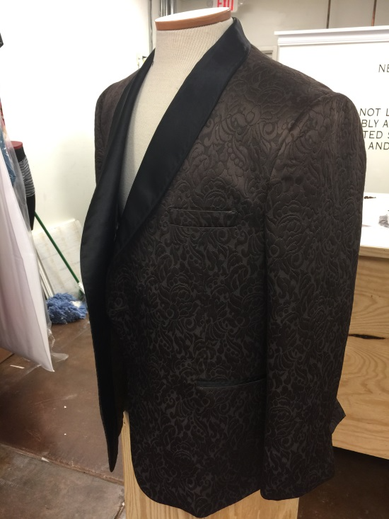 Black patterned blazer with satin shawl lapels on a mannequin.