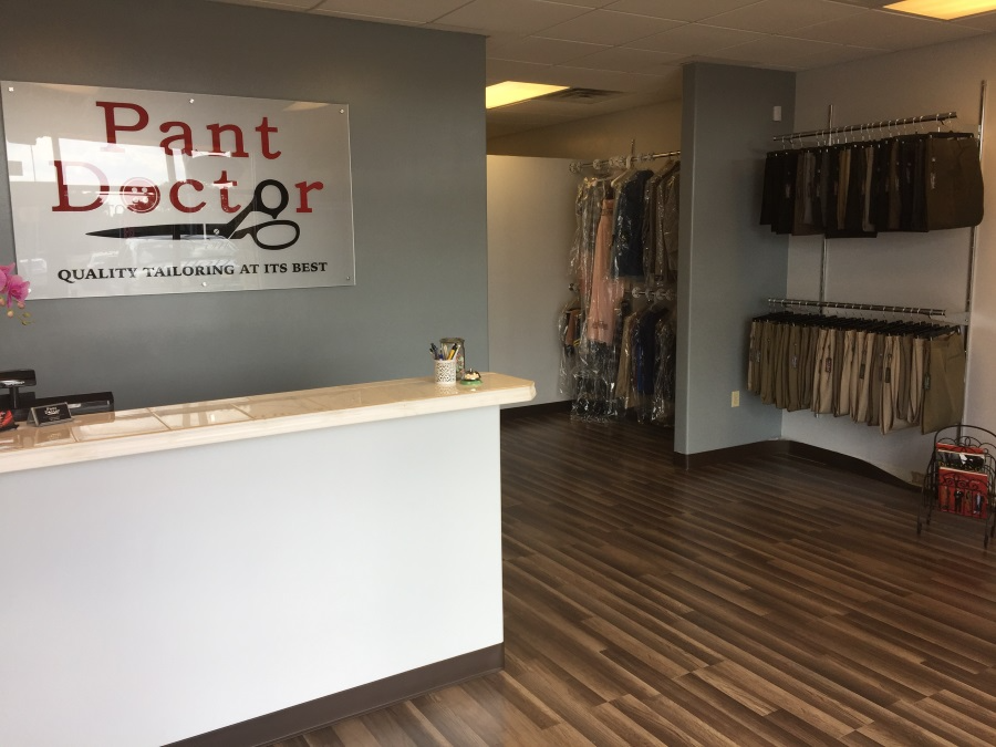 Paint Doctor storefront with white counter, brown wood floor, and clothing racks inside