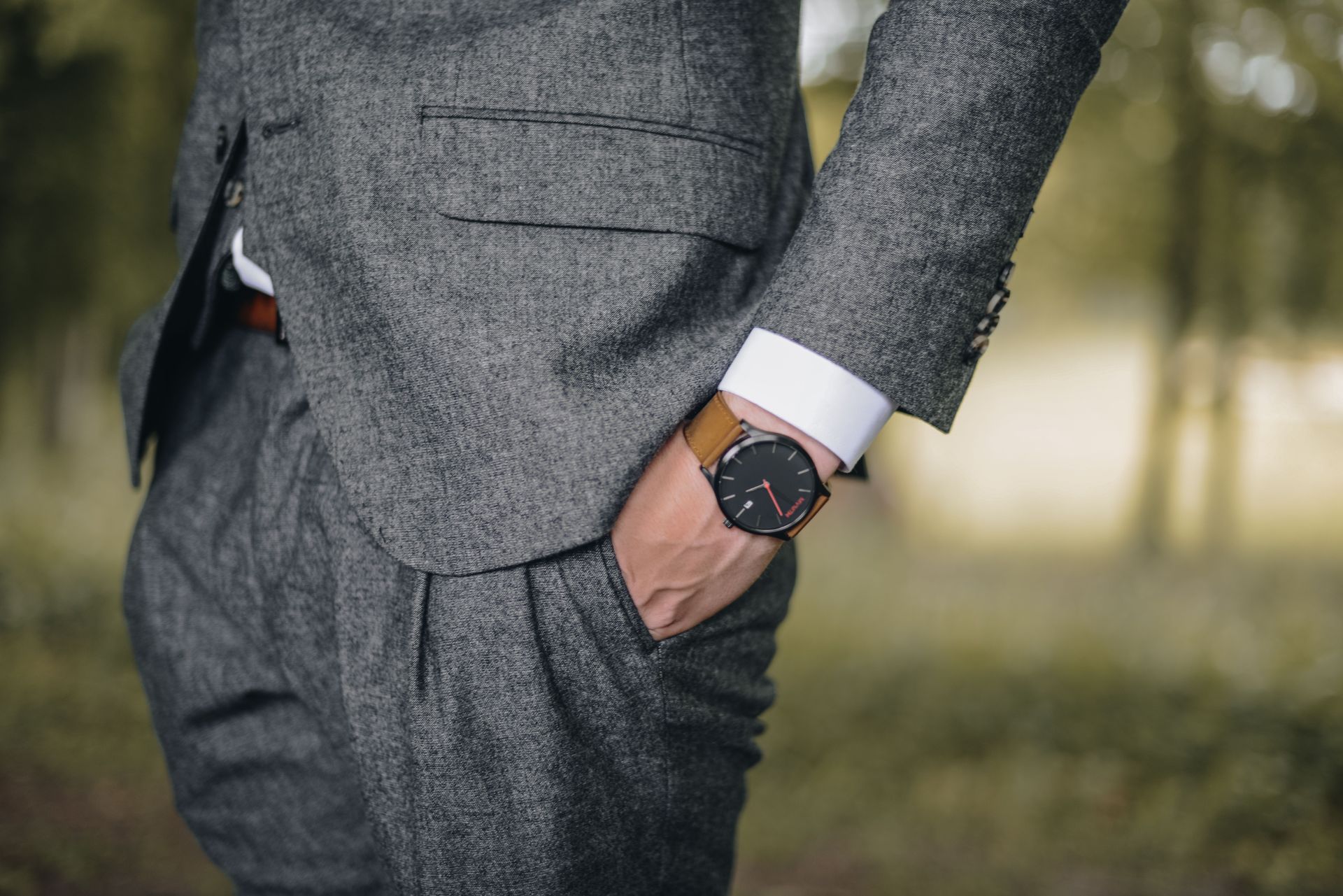 Tailor measuring a man’s suit jacket with a tape measure