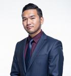 Man in dark suit, maroon shirt, and blue tie, looking at the camera against a white background.