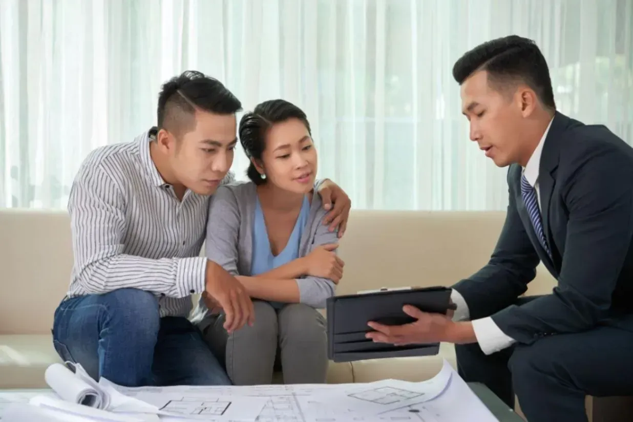 pasangan yang sedang survey rumah bersama agen properti