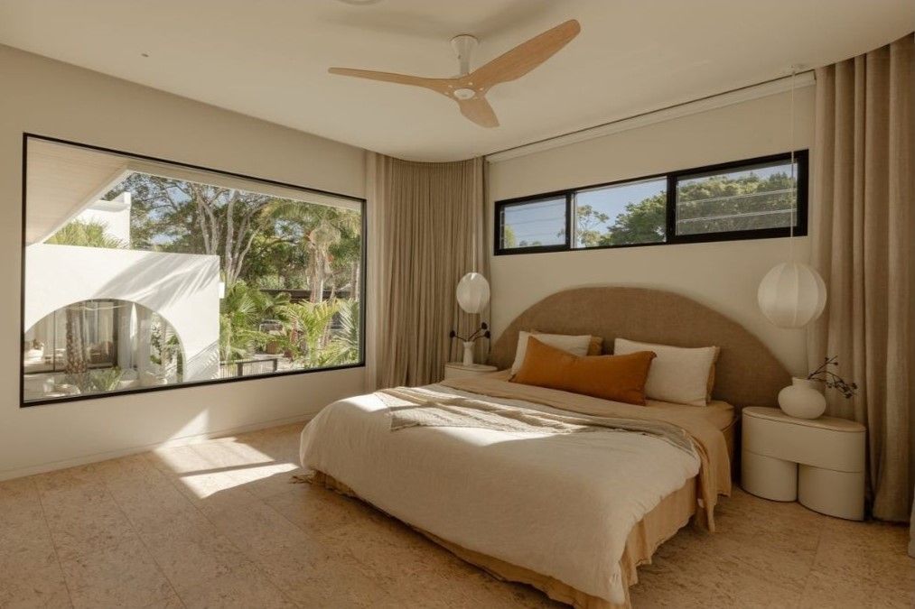 A Modern Bedroom With a Large Window, Bed, and Neutral Color Palette — Architectural Glass Solutions QLD in Cooroy, QLD