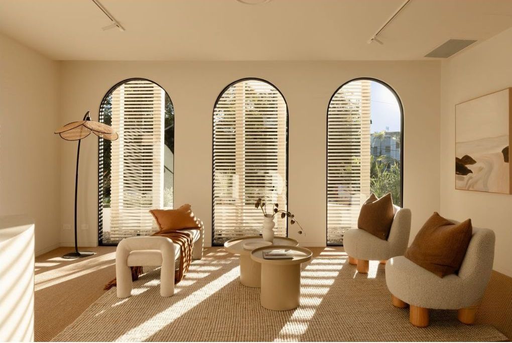 A Long Hallway With a Lot of Windows and a Green Exit Sign on the Wall — Architectural Glass Solutions QLD in Cooroy, QLD