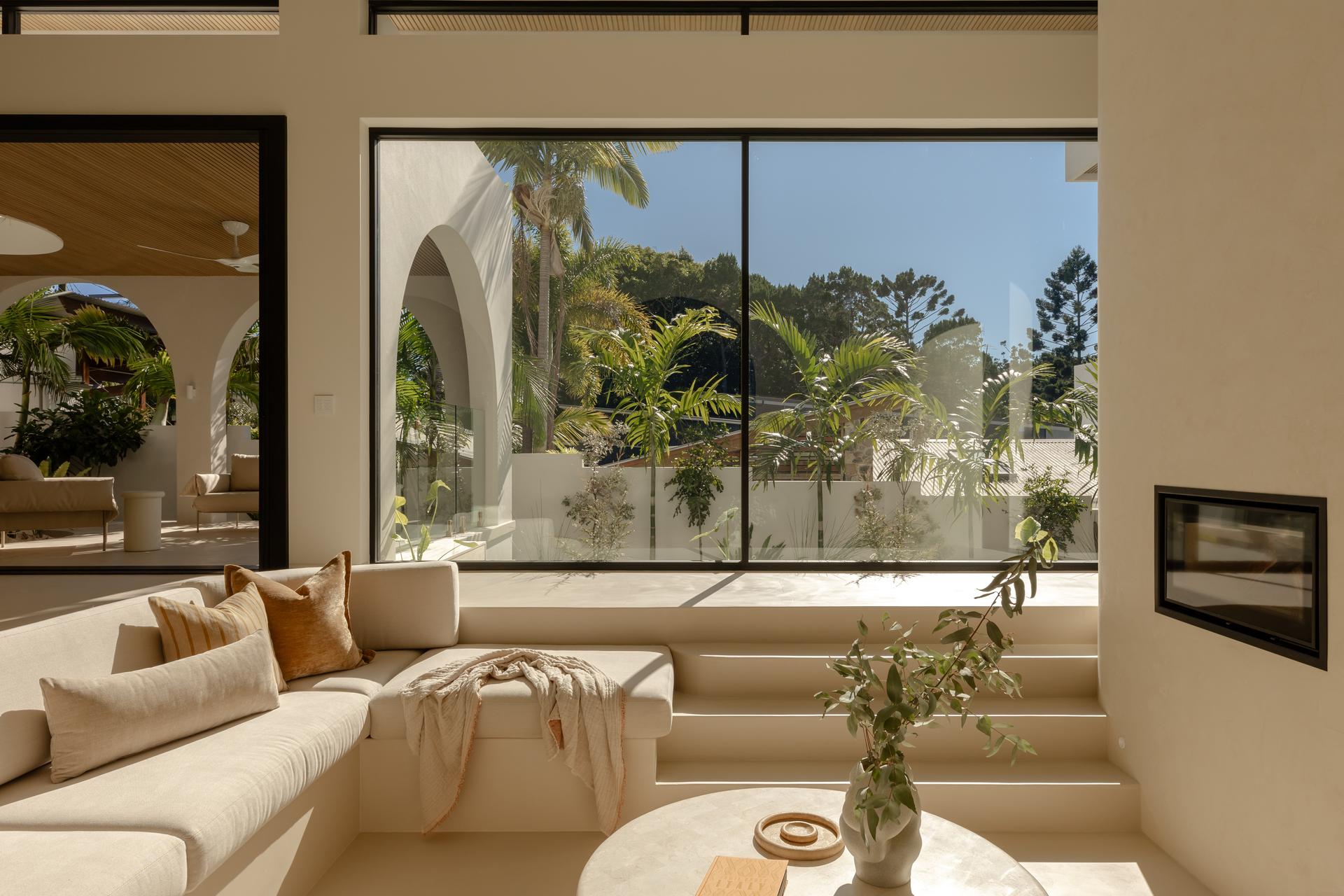 Bright Living Room With White Built-in Couch, a Window, and Fireplace — Architectural Glass Solutions QLD in Cooroy, QLD