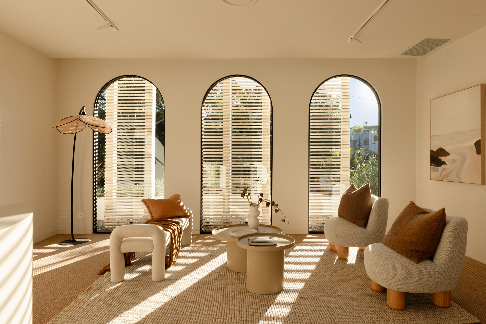 A Bright Room With Three Arched Windows With Wooden Shutters — Architectural Glass Solutions QLD in Cooroy, QLD