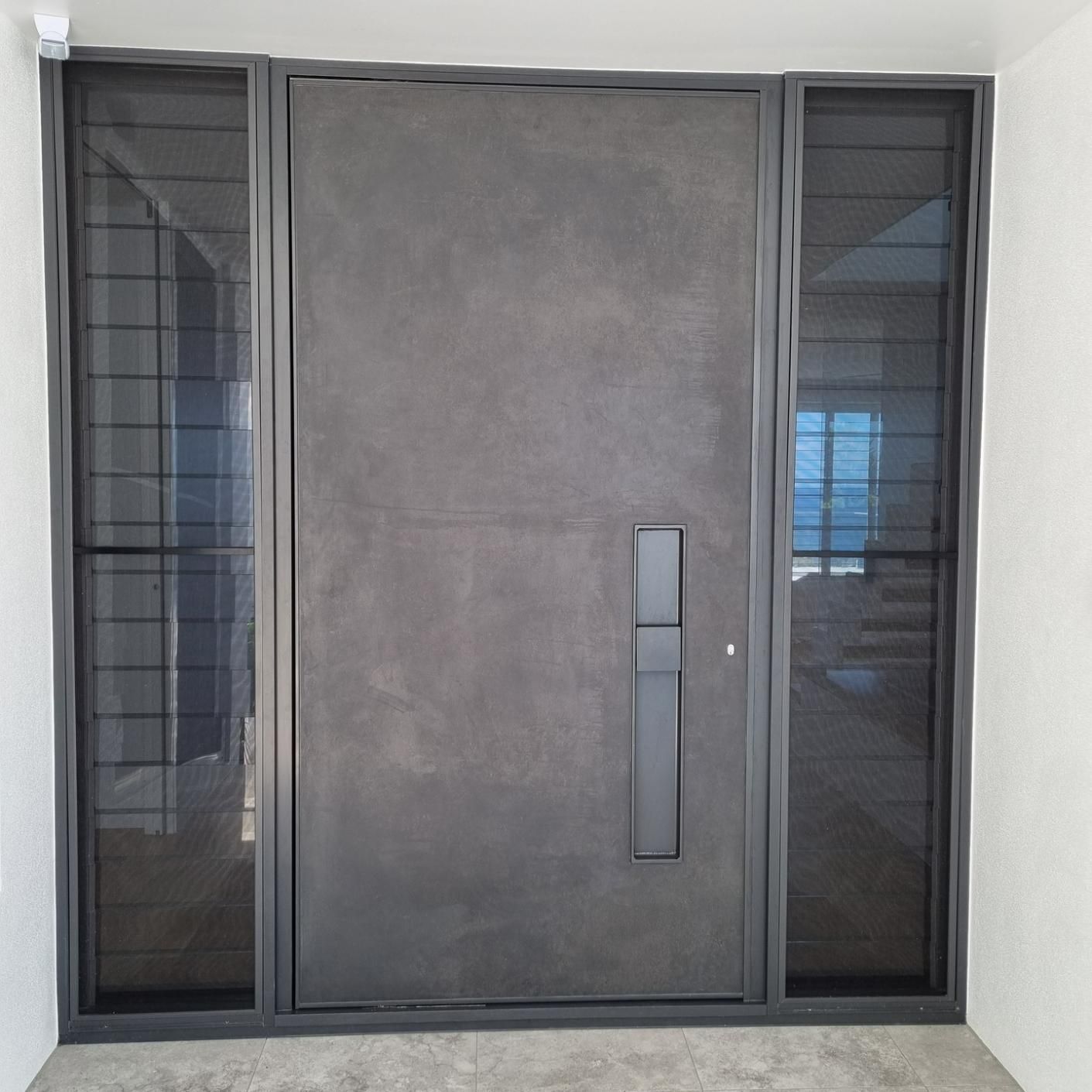 A Large Gray Door with A Handle and Two Windows in A Room — Architectural Glass Solutions QLD in Cooroy, QLD