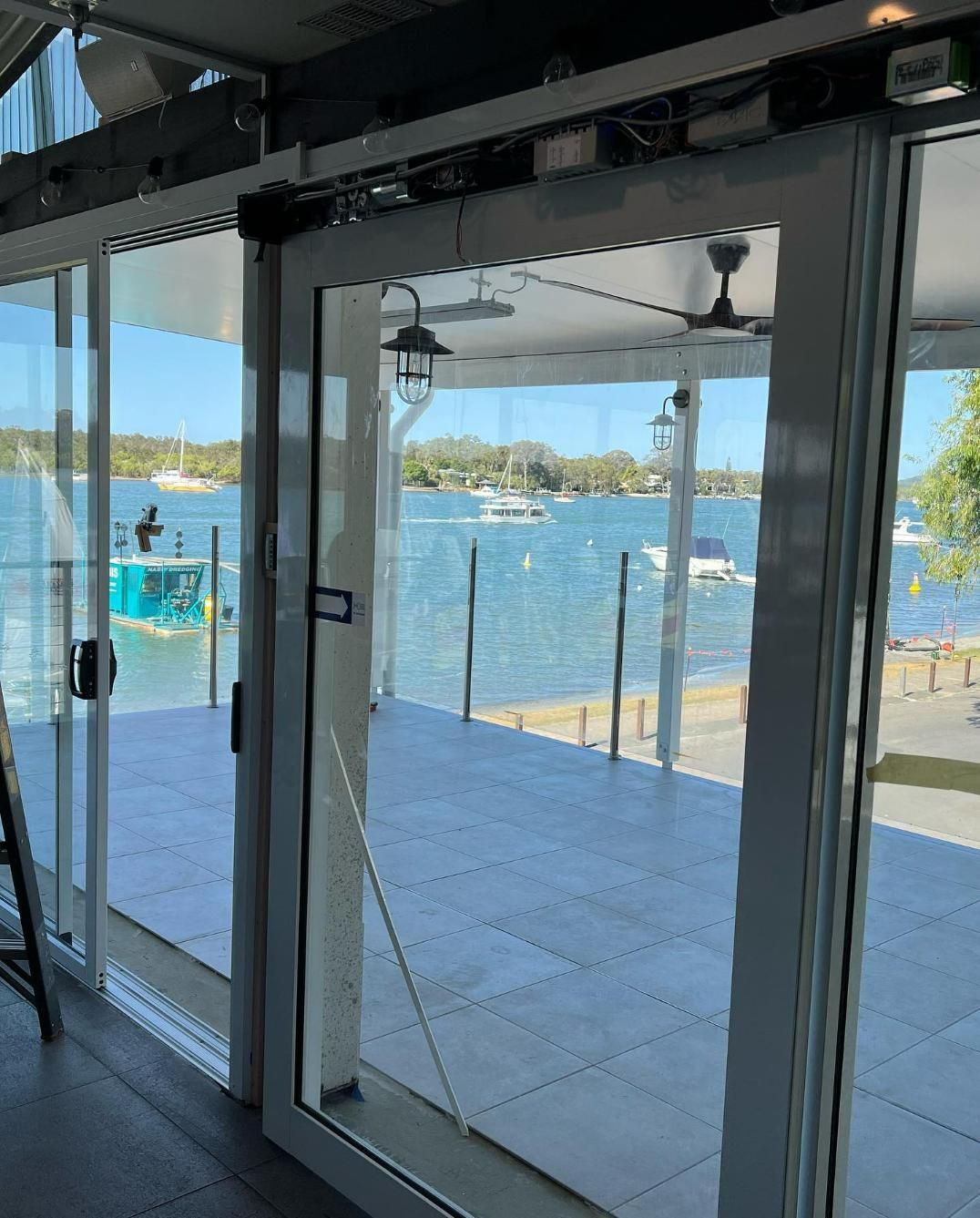 A View of A Body of Water Through a Sliding Glass Door — Architectural Glass Solutions QLD in Cooroy, QLD