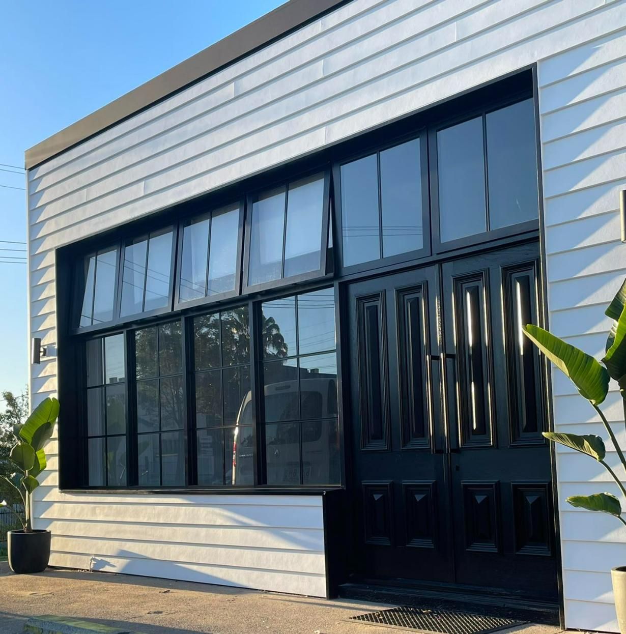 A Building with A Lot of Windows and A Black Door — Architectural Glass Solutions QLD in Cooroy, QLD