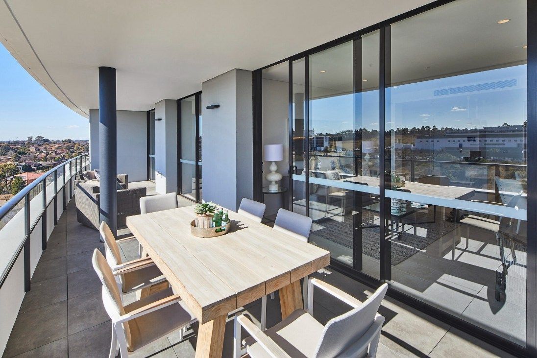 Outdoor Balcony With a Light Wood Dining Table, Chairs, and Glass Doors — Architectural Glass Solutions QLD in Cooroy, QLD