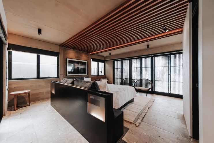 A Bedroom With a Large Bed , Couch , Television and Lots of Windows — Architectural Glass Solutions QLD in Cooroy, QLD