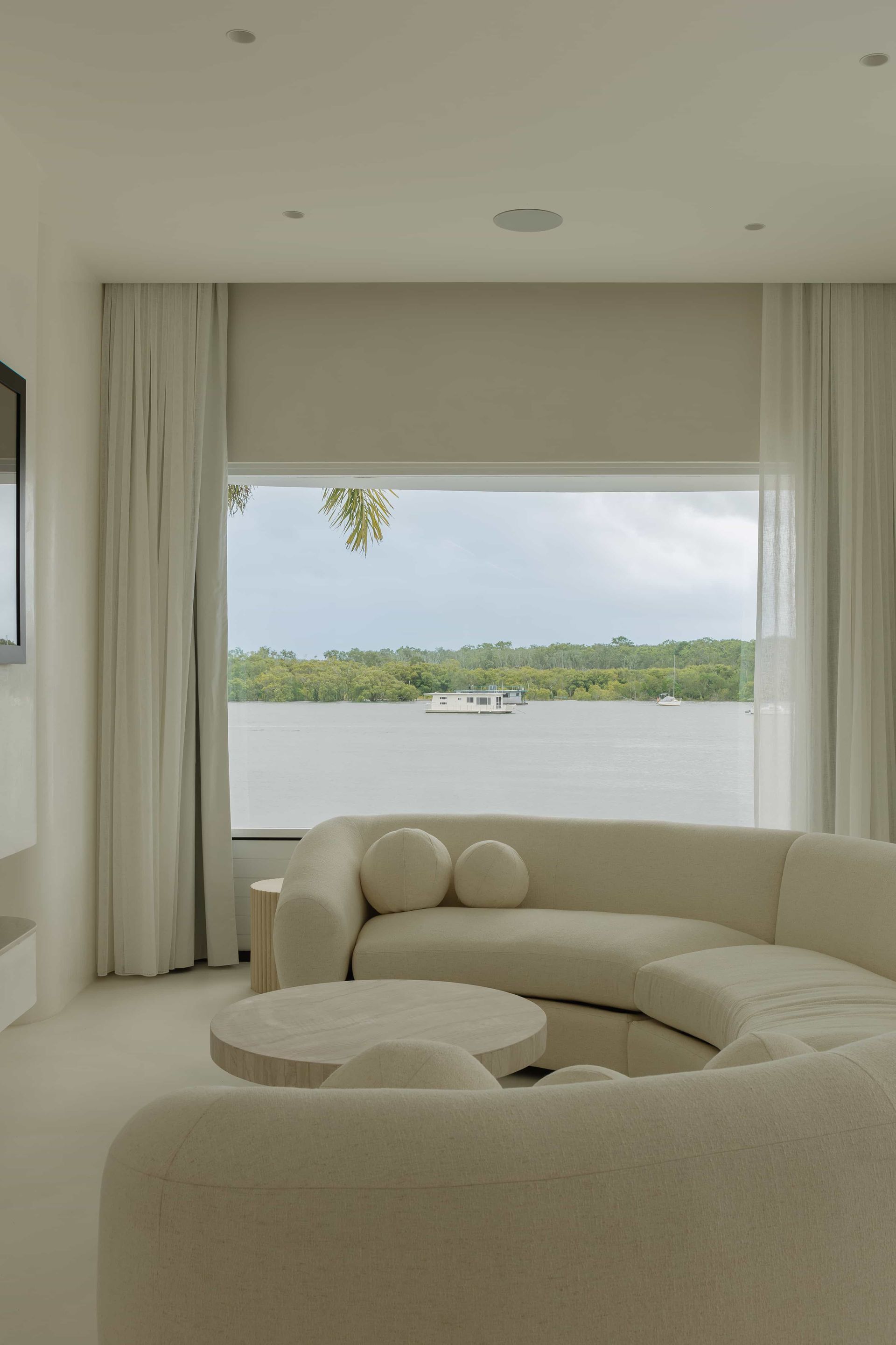 A living room with a white couch and a large window — Architectural Glass Solutions QLD in Cooroy, QLD