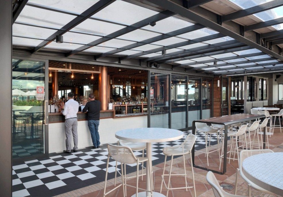 Outdoor Bar With Patrons, Checkerboard Floor, and Metal-framed Roof — Architectural Glass Solutions QLD in Cooroy, QLD