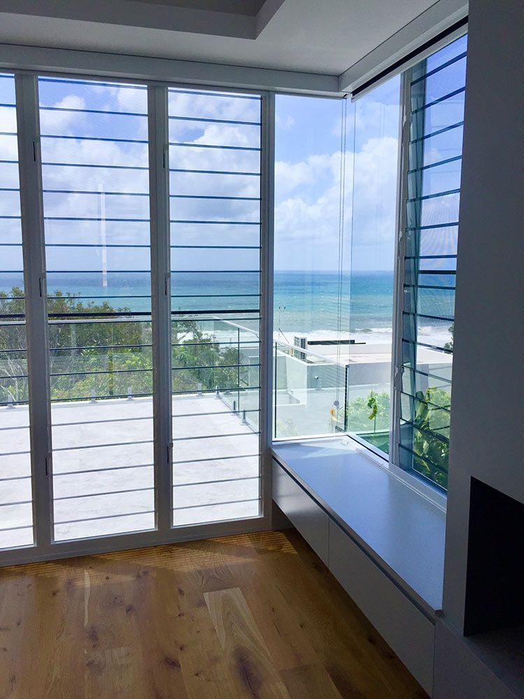 A Bright Room With Large Windows Offering Ocean Views — Architectural Glass Solutions QLD in Cooroy, QLD