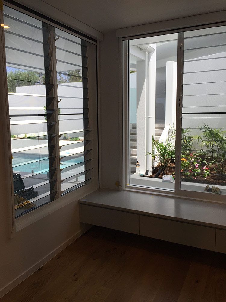 A Room With a Large Window Showcasing an Outdoor Pool and Garden — Architectural Glass Solutions QLD in Cooroy, QLD