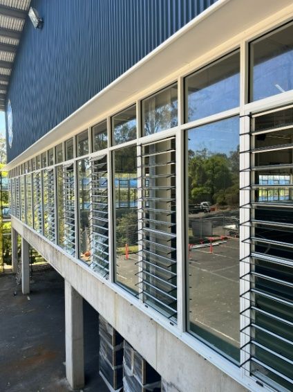 A Building With a Lot of Windows and a Blue Wall — Architectural Glass Solutions QLD in Cooroy, QLD