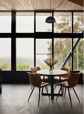 A Dining Room With a Round Table, Four Brown Chairs, and Large Windows — Architectural Glass Solutions QLD in Cooroy, QLD