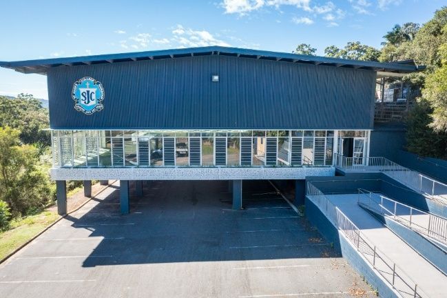 An Large Building With a Lot of Windows Surrounded by Trees — Architectural Glass Solutions QLD in Cooroy, QLD