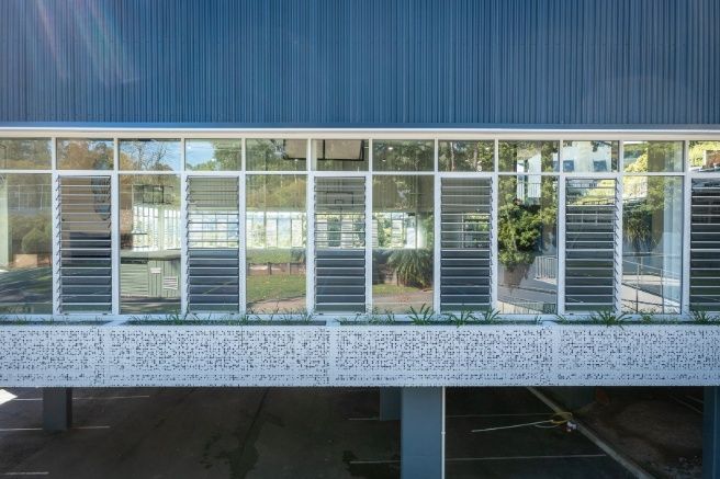 A Building With a Lot of Windows and a Parking Lot in Front of It — Architectural Glass Solutions QLD in Cooroy, QLD