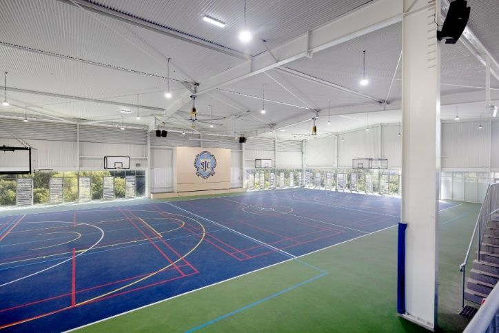 A Large Indoor Basketball Court With a Blue and Green Court — Architectural Glass Solutions QLD in Cooroy, QLD