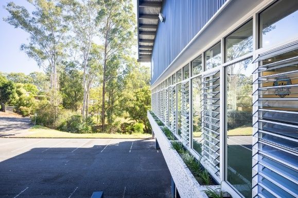 A Building With a Lot of Windows and Trees in the Background — Architectural Glass Solutions QLD in Cooroy, QLD