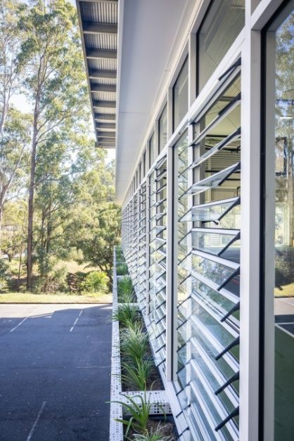 A Building With a Lot of Windows and Shutters on It — Architectural Glass Solutions QLD in Cooroy, QLD