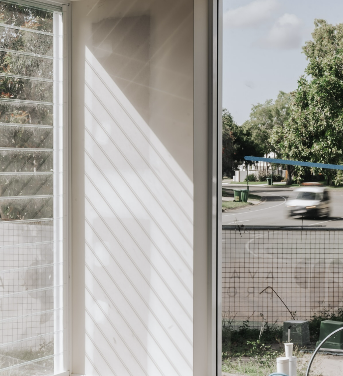 Sunlight Through a Window With Open Louvers Casts Striped Shadows on Wall — Architectural Glass Solutions QLD in Cooroy, QLD