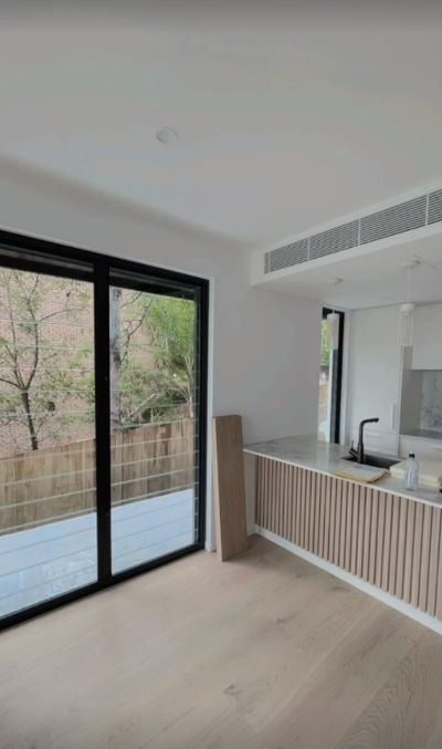 an Kitchen With a Light Wooden Floor and a Light Wood Paneled Island — Architectural Glass Solutions QLD in Cooroy, QLD