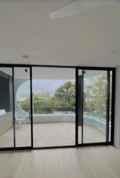 Sliding Glass Doors Open to a Balcony With a View of Trees — Architectural Glass Solutions QLD in Cooroy, QLD