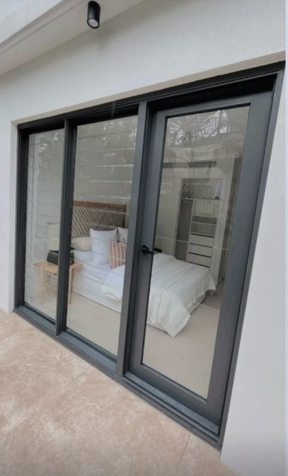 Exterior View of a Bedroom With Dark-framed Sliding Glass Doors — Architectural Glass Solutions QLD in Cooroy, QLD