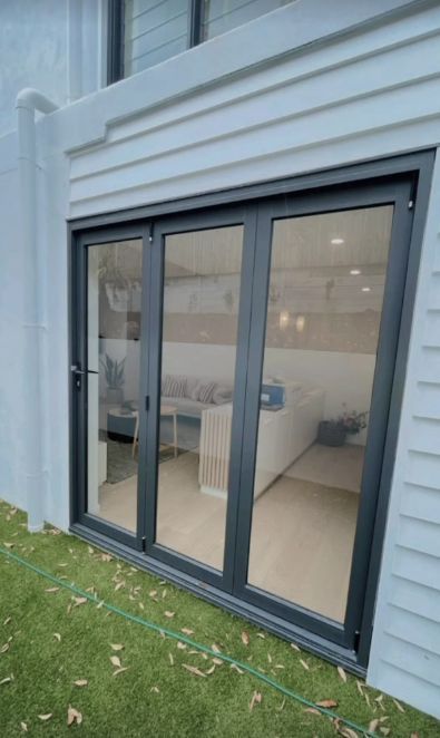 Black Framed Glass Doors on a White Building, Opening to a Living Room — Architectural Glass Solutions QLD in Cooroy, QLD