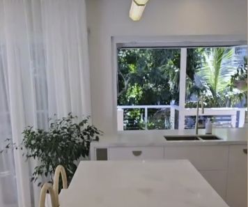 White Kitchen With a Large Window, Curtains, and a Countertop With a Sink — Architectural Glass Solutions QLD in Cooroy, QLD