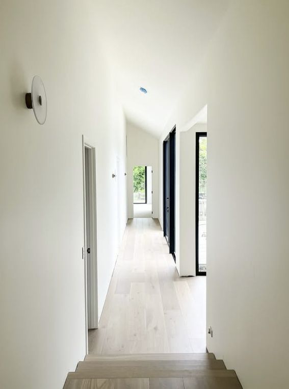 Narrow Hallway With Light Wood Floors, White Walls, and a Sloped Ceiling — Architectural Glass Solutions QLD in Cooroy, QLD