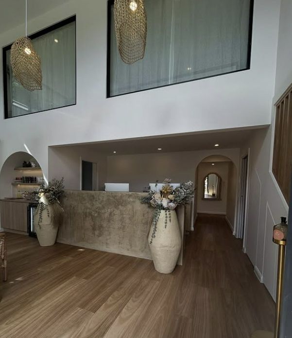 Reception Area With Stone Counter, Floral Arrangements & Wooden Floors — Architectural Glass Solutions QLD in Cooroy, QLD