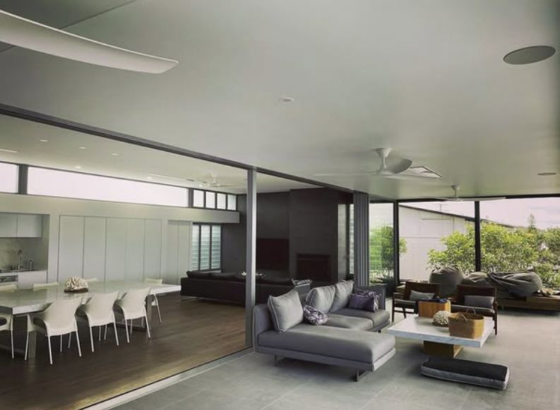 Modern Living Room With Sliding Glass Doors, Dining Area & Gray Sofa — Architectural Glass Solutions QLD in Cooroy, QLD
