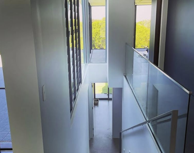 Interior View Looking Down Bright Hallway With Staircase & Glass Railing — Architectural Glass Solutions QLD in Cooroy, QLD