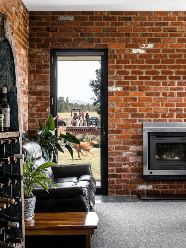 A Room With Exposed Brick Walls, a Leather Couch, and a Black-framed Door  — Architectural Glass Solutions QLD in Cooroy, QLD