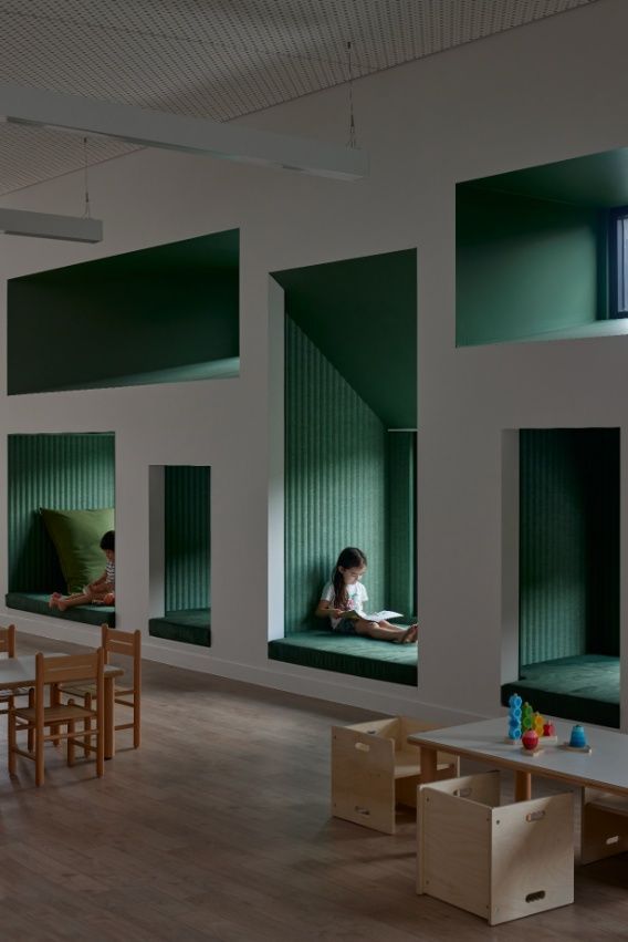 A Child Sits on a Bench in a Room With Tables and Chairs — Architectural Glass Solutions QLD in Cooroy, QLD