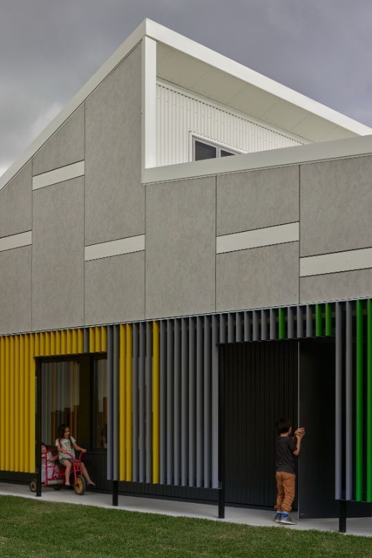 A Building With Yellow and Green Siding and a White Roof — Architectural Glass Solutions QLD in Cooroy, QLD