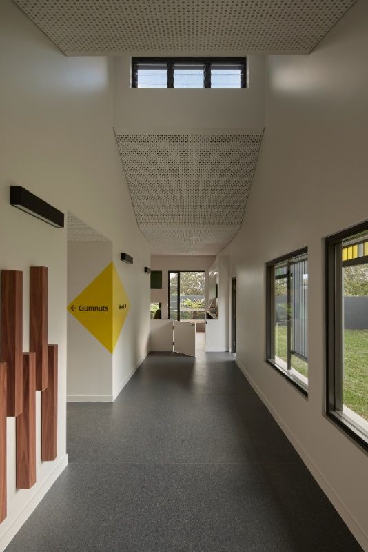 A Long Hallway in a Building With a Yellow Sign — Architectural Glass Solutions QLD in Cooroy, QLD
