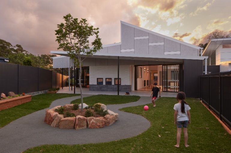 A Boy and a Girl Are Playing With a Ball in the Backyard of a House — Architectural Glass Solutions QLD in Cooroy, QLD