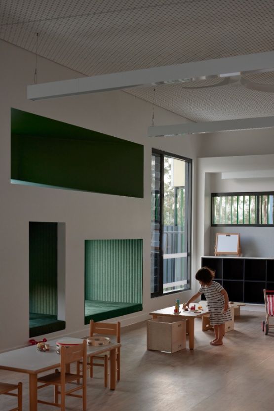 A Little Girl Sits at a Table in a Room With Tables and Chairs — Architectural Glass Solutions QLD in Cooroy, QLD