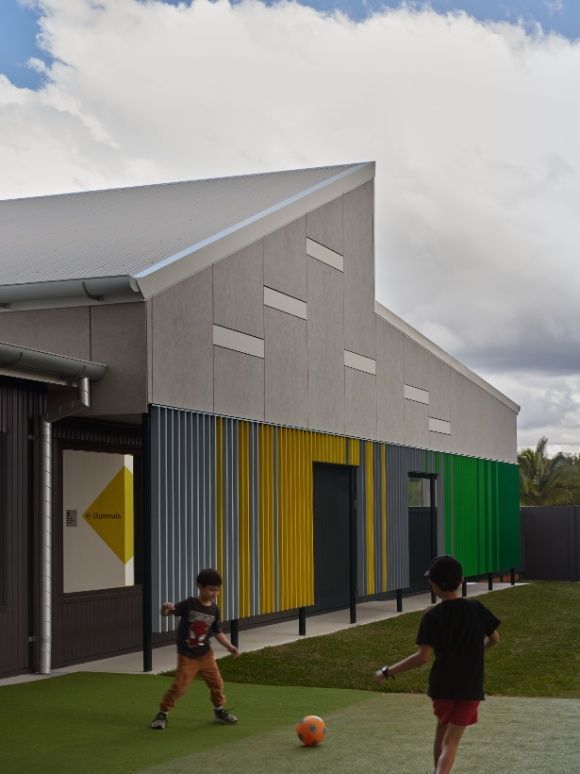 Two Children Are Playing With a Soccer Ball in Front of a Building — Architectural Glass Solutions QLD in Cooroy, QLD