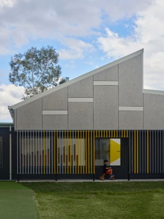 A Person Riding a Tricycle in Front of a Building — Architectural Glass Solutions QLD in Cooroy, QLD