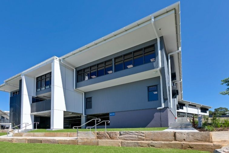 A Large Building With a Lot of Windows is Sitting on Top of Hillside  — Architectural Glass Solutions QLD in Cooroy, QLD